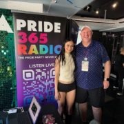 Artist Daya stands next to Houston by a Pride365 Radio Banner