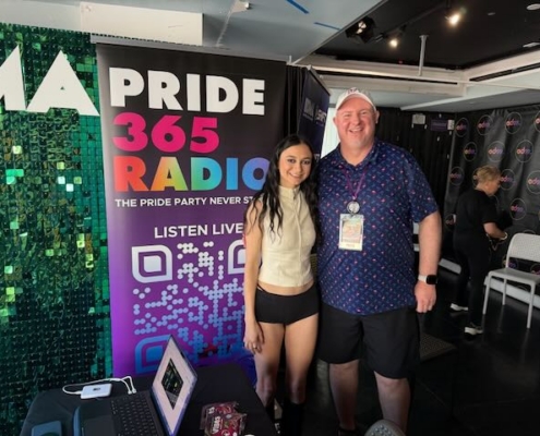 Artist Daya stands next to Houston by a Pride365 Radio Banner